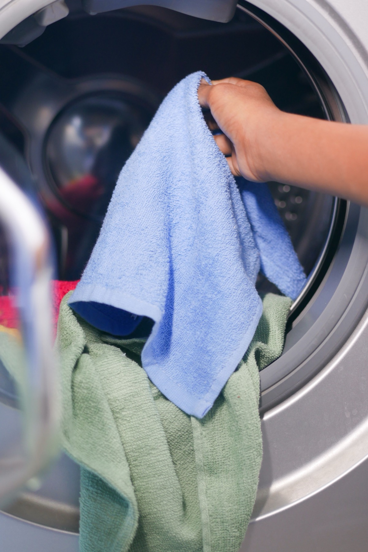 Clothes being loaded into a washing machine